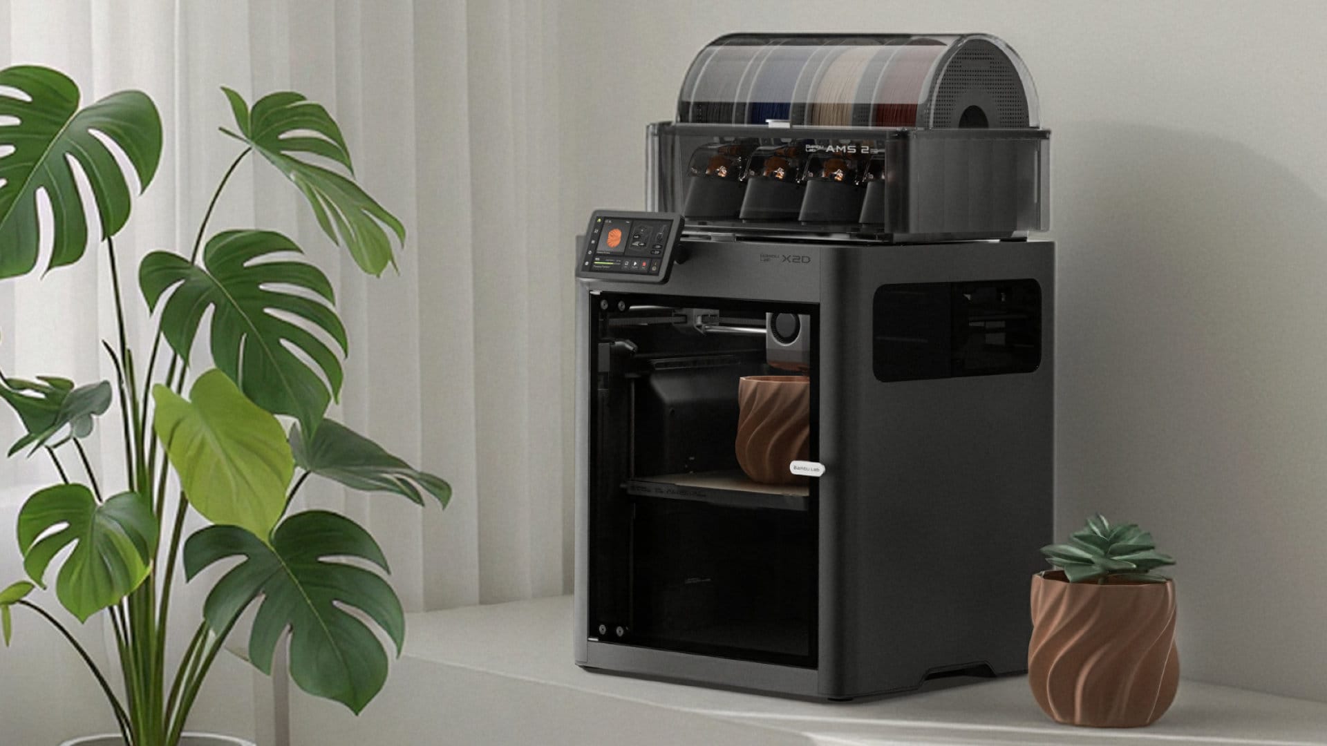 Bambu Lab X2D 3D printer with an AMS unit, shown in an official product photograph