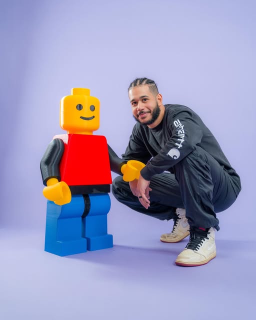 Youssef beside his oversized 3D printed brick figure